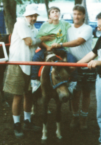 Paul helping his son James ride a horse for the first time